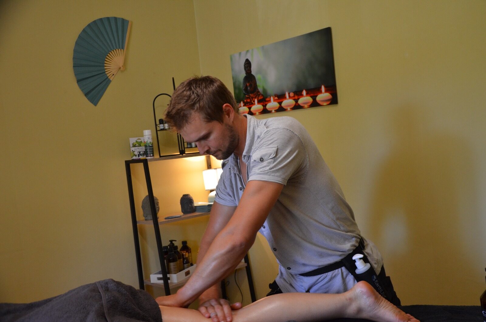 Nicolas en pleine séance de massage dans son salon, lumière chaleureuse